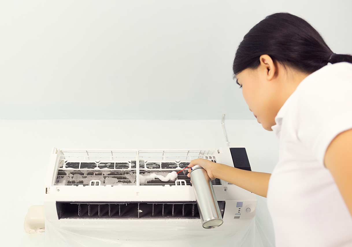 woman cleaning air conditioner