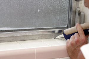 Man applying caulk to a window frame