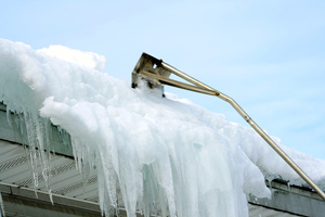 snow rake removing snow from roof