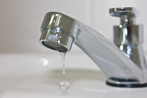 closeup of dripping bathroom sink faucet