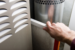 hand changing home furnace filter