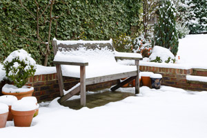 snow-covered patio bench and pots