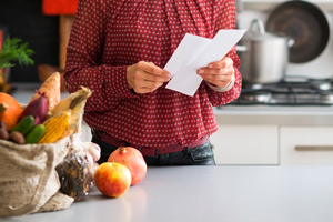 woman with shopping list in kitchen